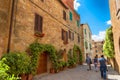 Pienza, Italy Ã¢â¬â May 27, 2017: Beautiful narrow street with sunlight and flowers in the village of Pienza, Italy Royalty Free Stock Photo